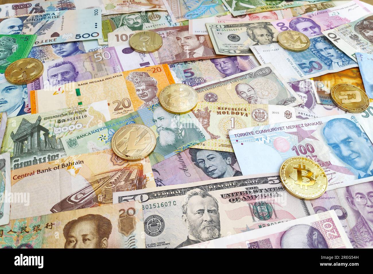 Paris, Frankreich - Juli 30 2019: Kryptowährungsmünzen auf einem Stapel internationaler Banknoten (US-Dollar, australische und Singapur-Dollar, Ringgit, Tugr Stockfoto