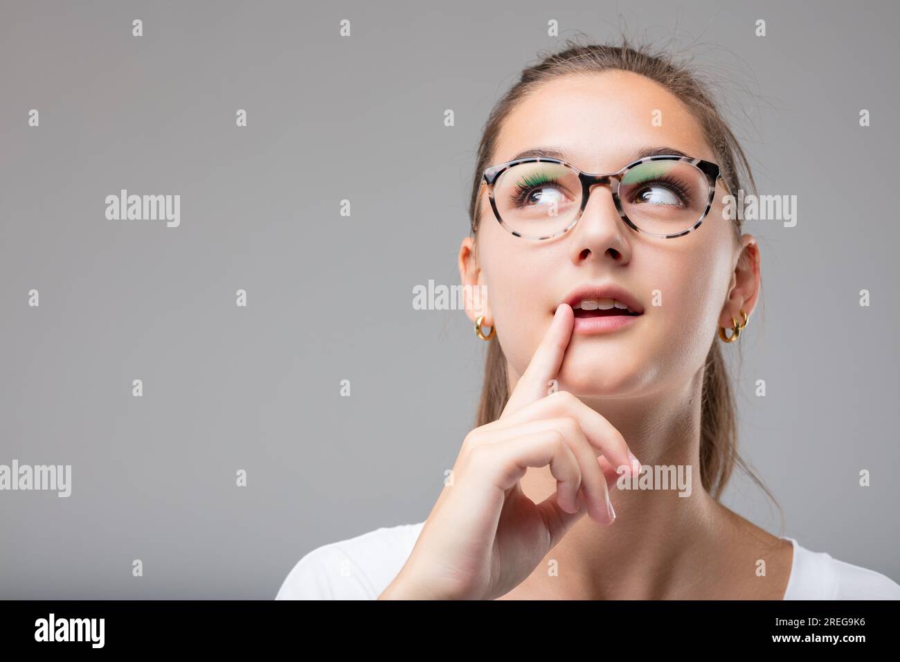 Das Gesicht einer jungen Frau zeigt ihr Genie; sie hatte einen aufschlussreichen Gedanken, indem sie Ideen zu einem neuen Konzept verband Stockfoto