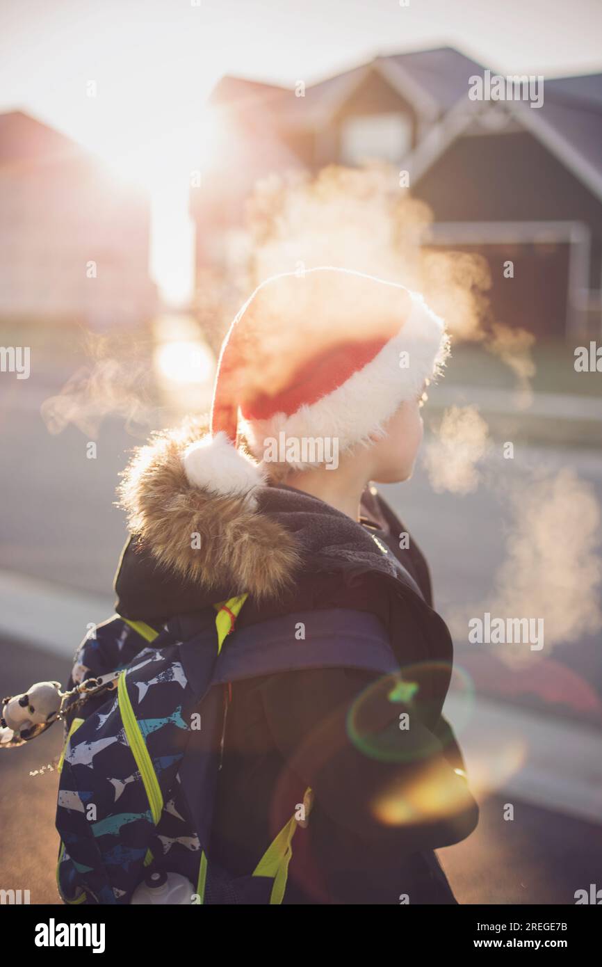 Junge träumt von weihnachtsliste und Winterferien an der Bushaltestelle Stockfoto