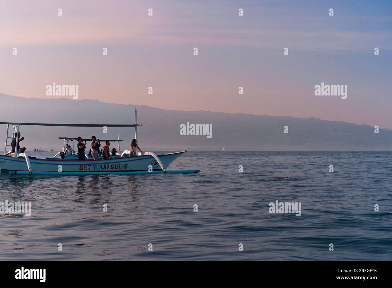 Touristen auf der Suche nach Delfinen in Lovina auf Bali. Morgendliche Bootsfahrten. Stockfoto