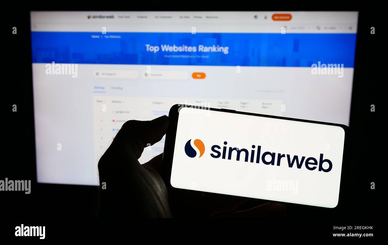 Person, die ein Smartphone mit dem Logo des israelischen Webanalyseunternehmens SimilarWeb Ltd. Auf dem Bildschirm vor der Website hält. Konzentrieren Sie sich auf das Display des Telefons. Stockfoto