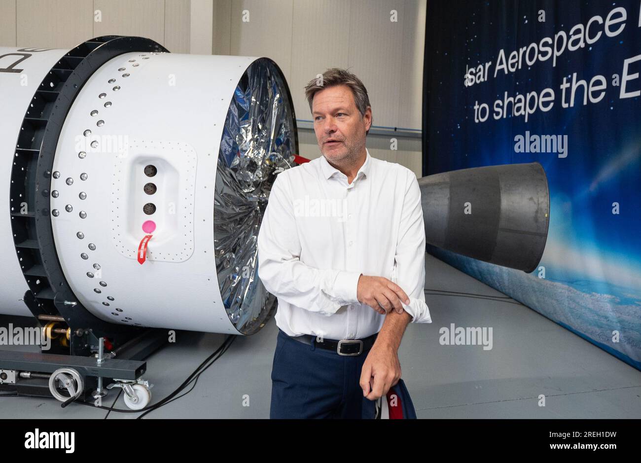 Ottobrunn, Deutschland. 28. Juli 2023. Der deutsche Wirtschaftsminister Robert Habeck (Bündnis 90/die Grünen) geht bei einem Besuch des Raumfahrtunternehmens Isar Aerospace an einer Raketenprototypenrakete vorbei. Kredit: Marijan Murat/dpa/Alamy Live News Stockfoto