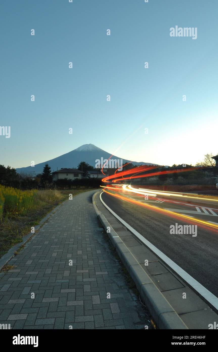 Stadtbild in Bewegung: Ein Bürgersteig mit leeren Straßen in abgelegener Gegend und Fuji-Berg im Hintergrund Stockfoto