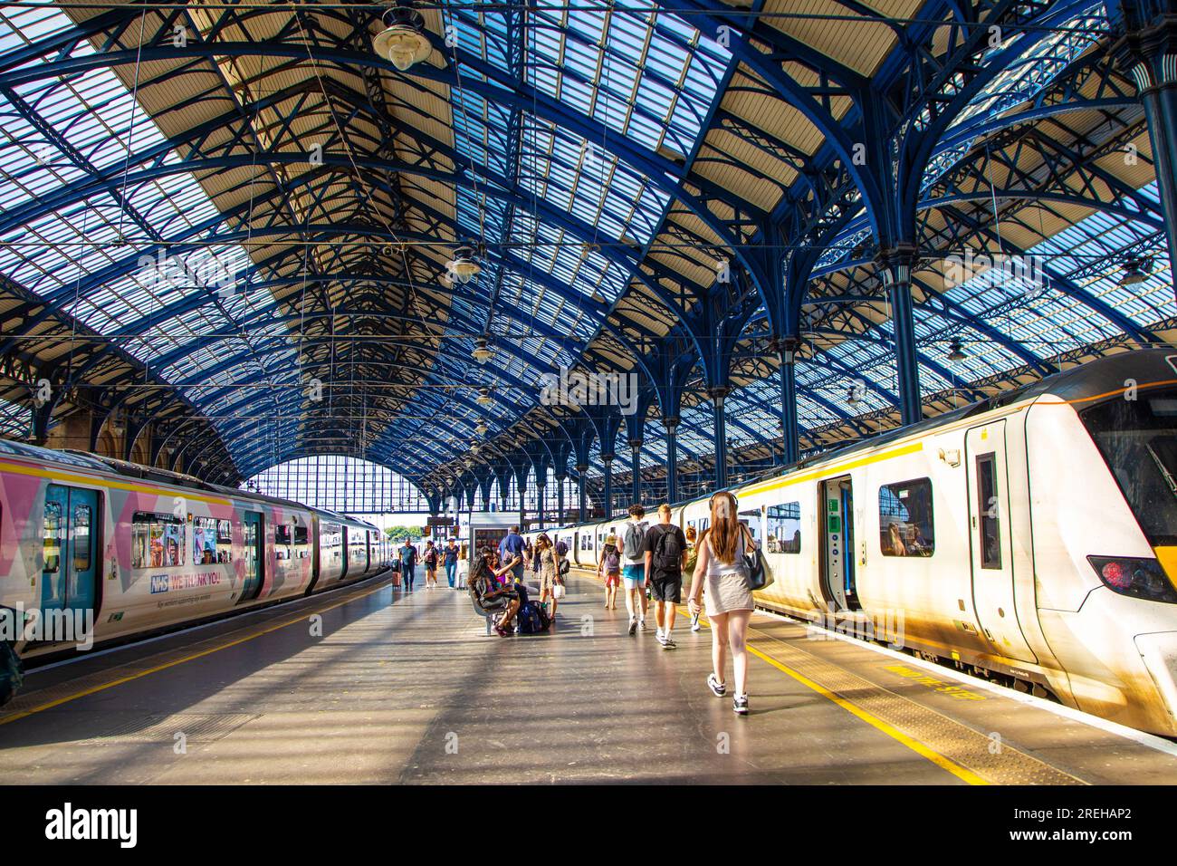 Leute, die am Bahnsteig in Brighton Station, Brighton, East Sussex, England entlang laufen Stockfoto
