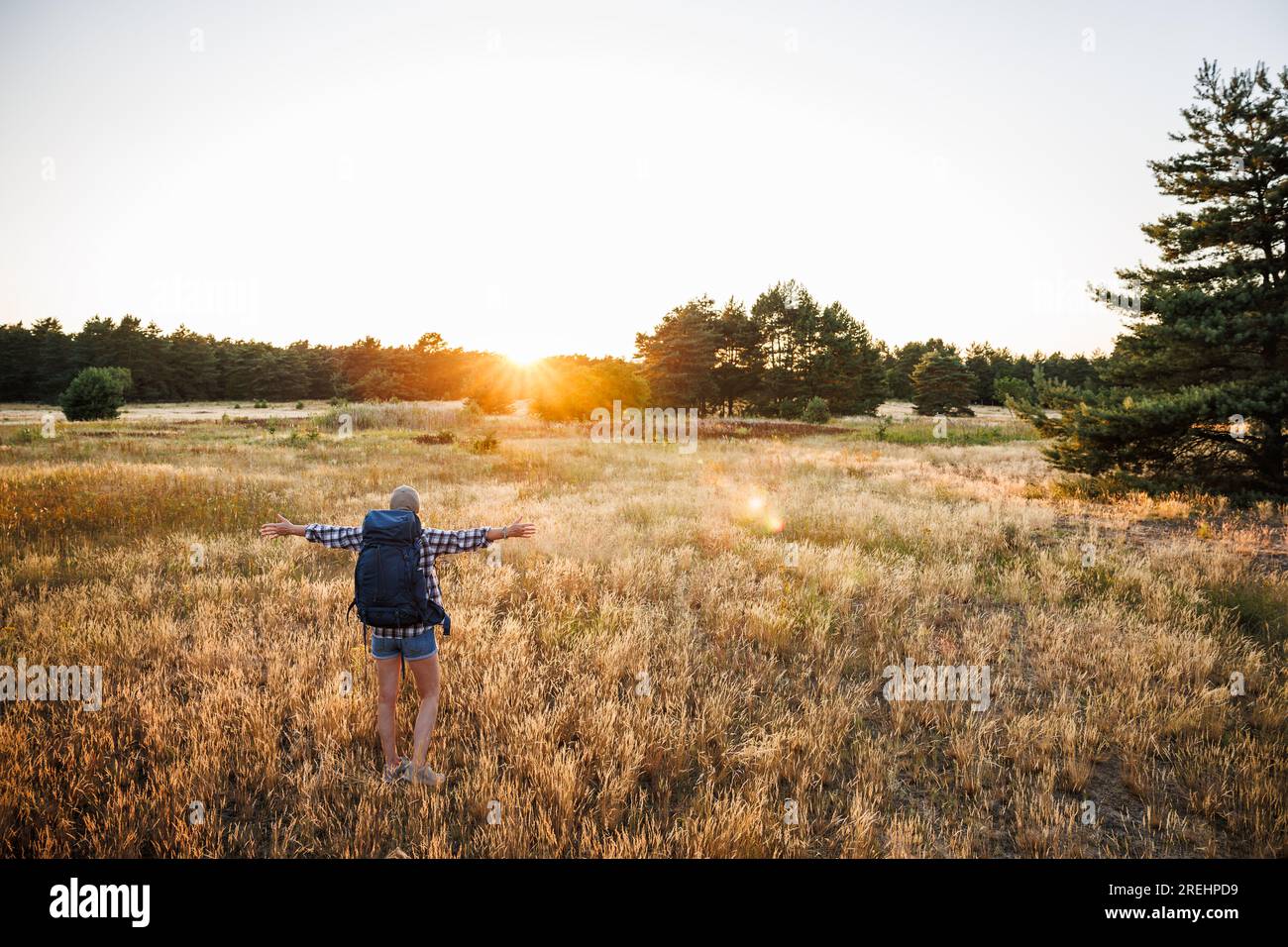 Glückliche Frau hat den perfekten Ort gefunden, um vor Sonnenuntergang im Freien zu campen. Wandern und Trekking in der SommerNatur Stockfoto