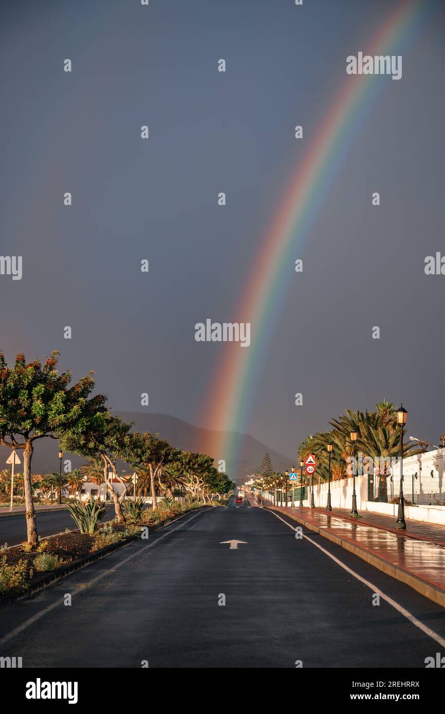 Regenbogen über Sanddünen und eine Dünenstraße. Corralejo Nationalpark am Morgen, Provinz Las Palmas, Fuerteventura, Kanarische Inseln, Spanien Stockfoto