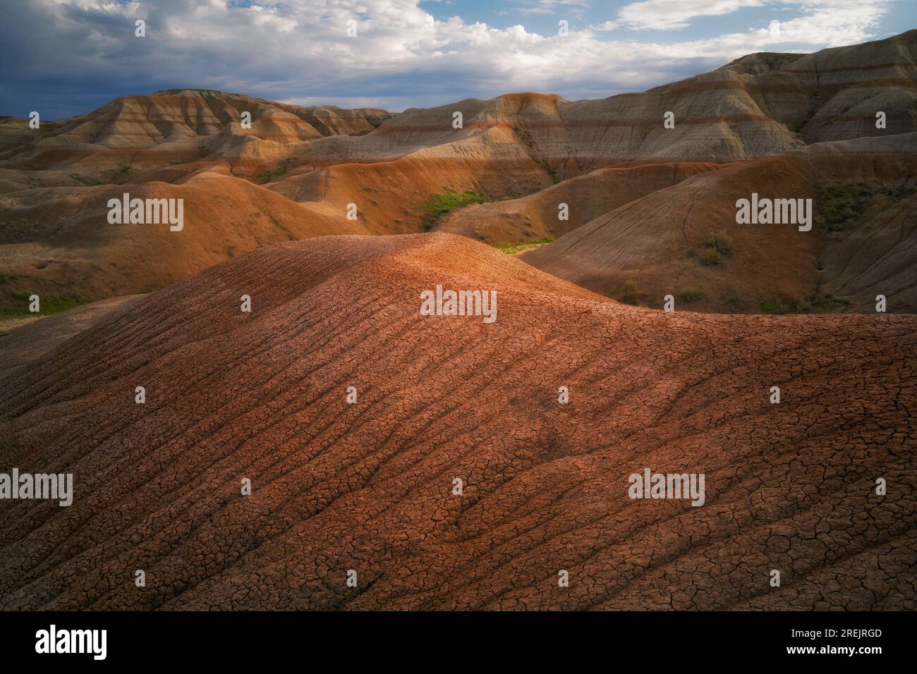 Bei Sonnenaufgang werden diese erodierten Muster von Schlamm auf den Hügeln unterhalb des Conata Basin im Badlands-Nationalpark in South Dakota enthüllt. Stockfoto