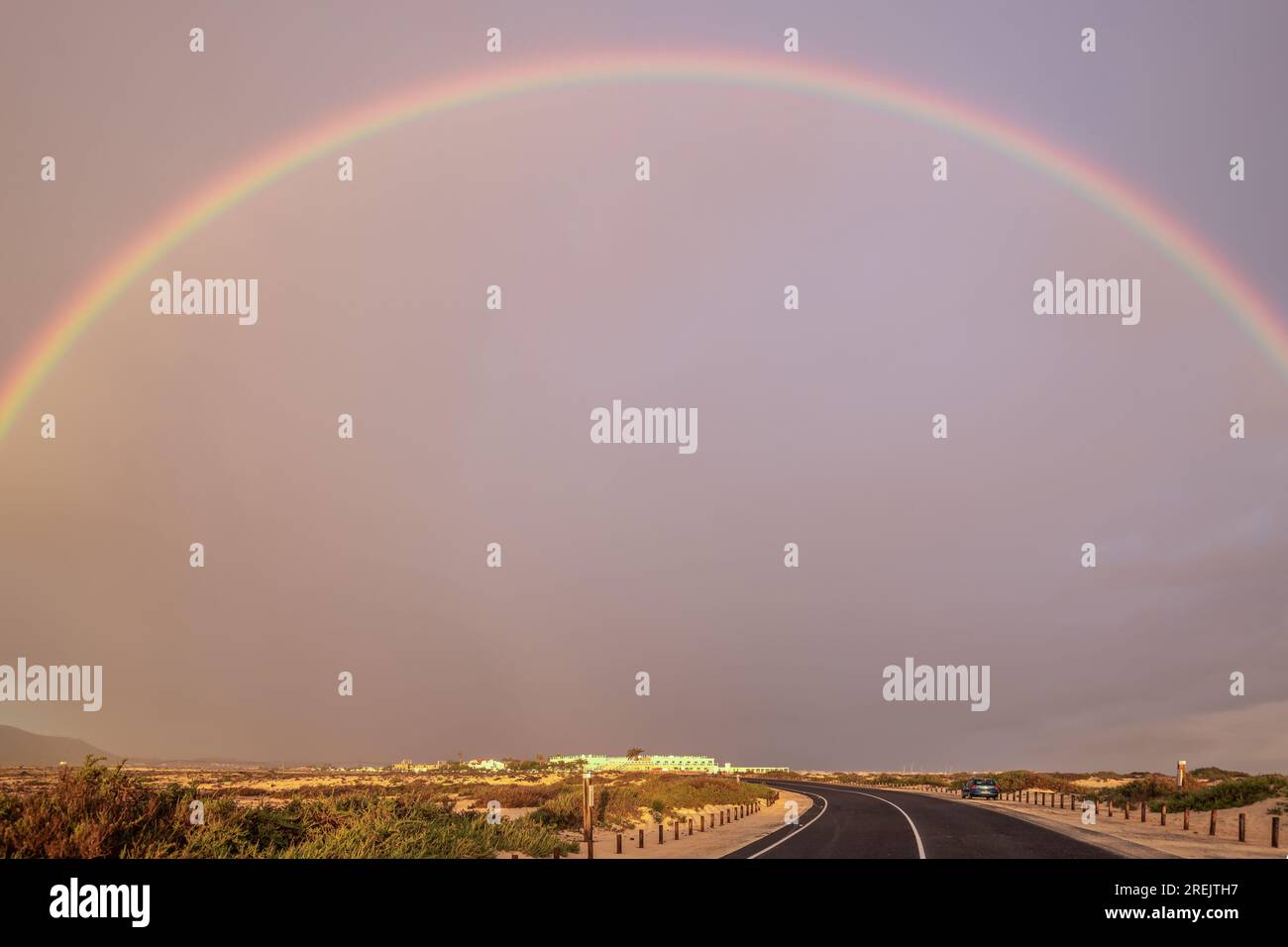 Regenbogen über Sanddünen und eine Dünenstraße. Corralejo Nationalpark am Morgen, Provinz Las Palmas, Fuerteventura, Kanarische Inseln, Spanien Stockfoto