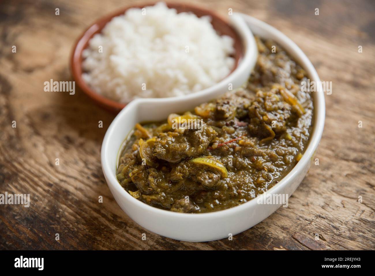 Ein Curry mit Holztaubenfilets, serviert mit weißem Reis. Zu den Zutaten gehören Zwiebeln, Knoblauch und eine Reihe von Gewürzen. England GB Stockfoto