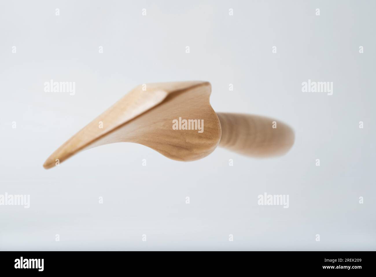 Handgefertigtes Küchenutensil aus Holz, aus Kirschholz, fotografiert auf einem glatten weißen Hintergrund mit Platz für Typ. Stockfoto