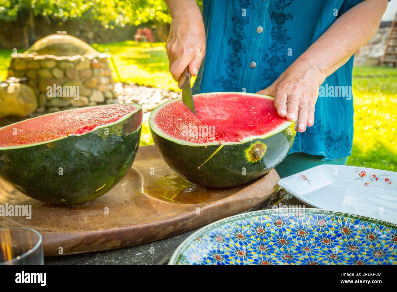 Nahaufnahme eines Mannes, der eine Wassermelone schneidet Stockfoto