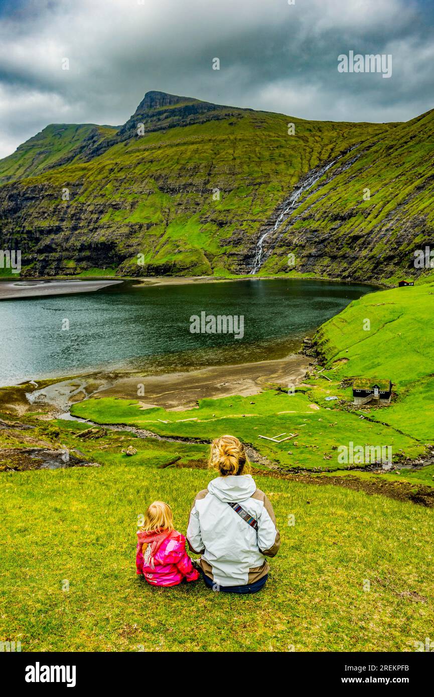 Frau mit ihrem Kind, die den wunderschönen Fjord von Saksun, Streymoy, Färöer Inseln, Dänemark ansieht Stockfoto
