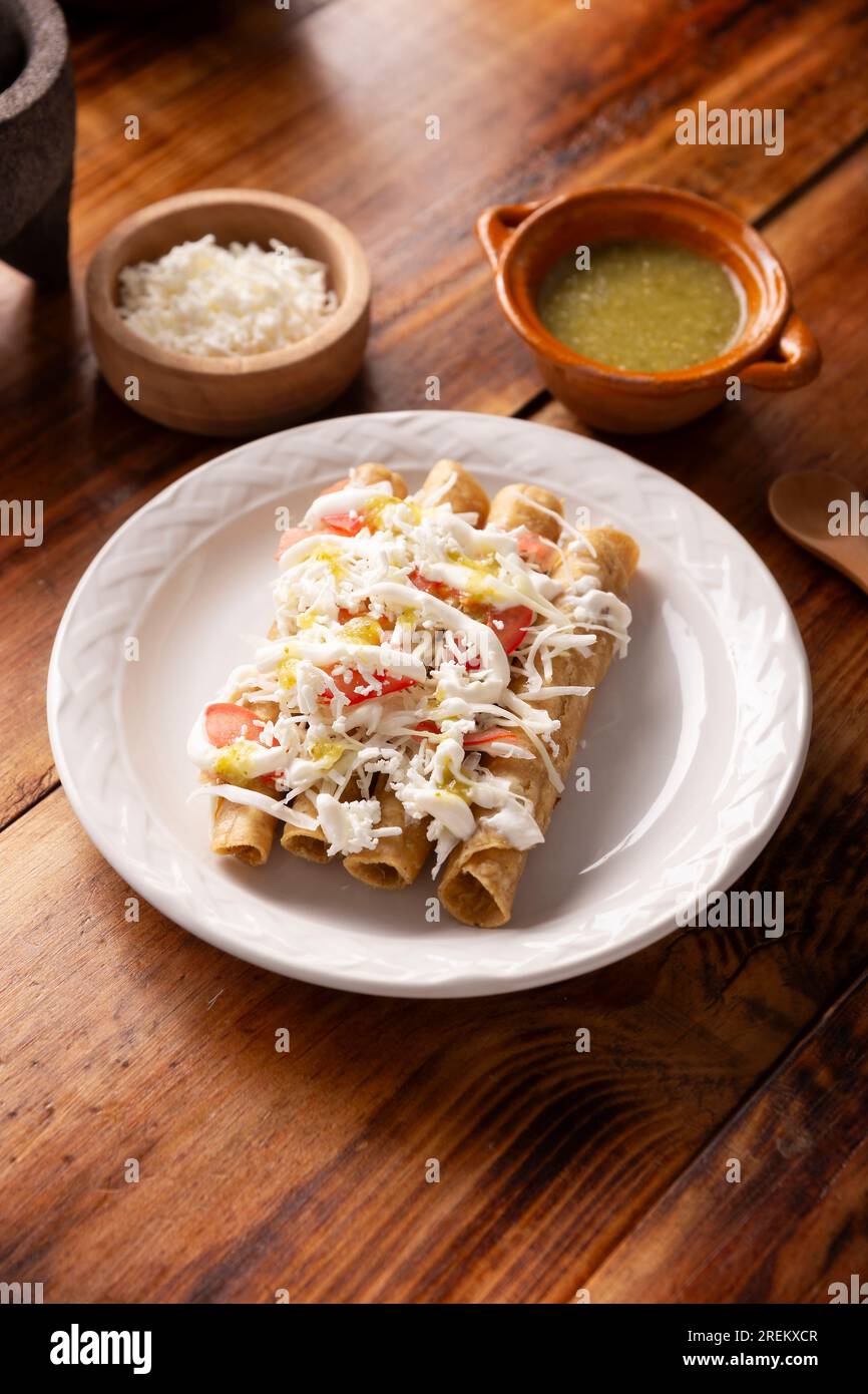 Tacos Dorados. Mexikanisches Gericht, auch bekannt als Flautas, besteht aus einer gerollten Maistortilla mit etwas Füllung, in der Regel Huhn oder Rindfleisch oder vegetarische Option Stockfoto