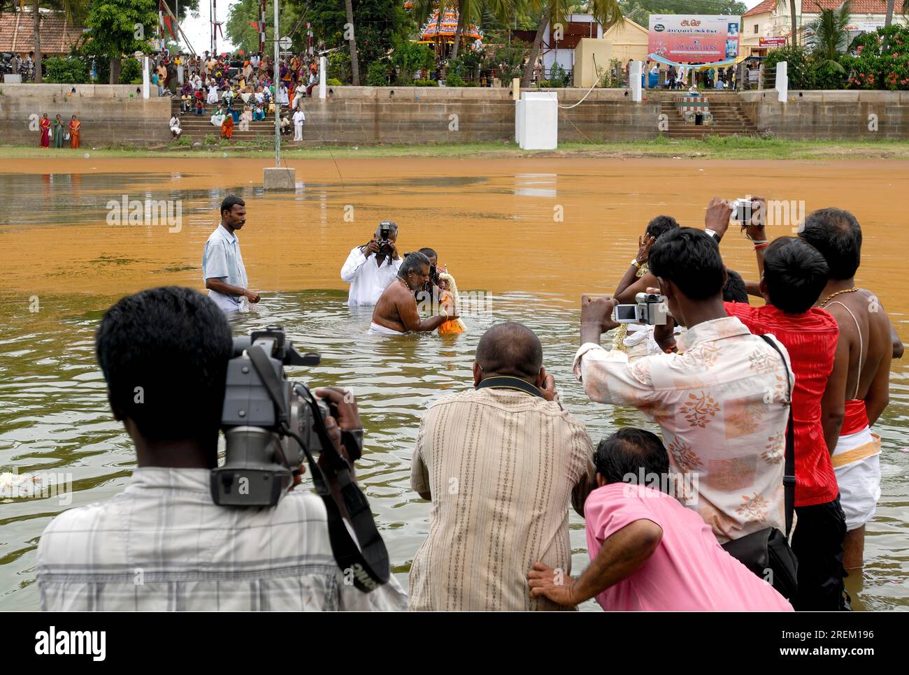 Tempelpriester, der mit der Urchava-Gottheit während des Vinayak Chaturthi Ganesh Chaturthi Festivals im Sri Karpaga Vinayakar Temple in Wasser taucht Stockfoto