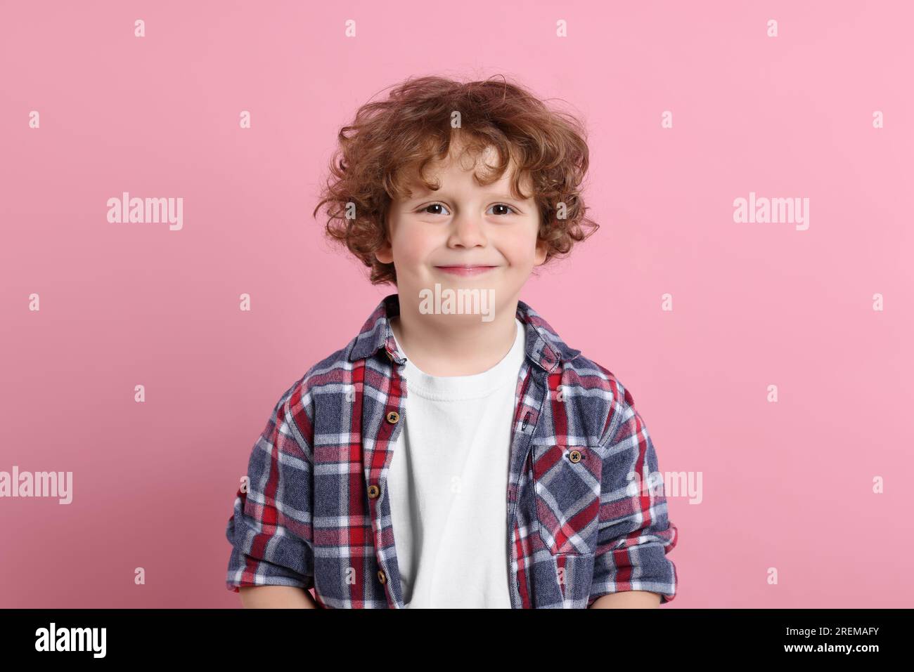 Porträt eines süßen kleinen Jungen auf pinkfarbenem Hintergrund Stockfoto