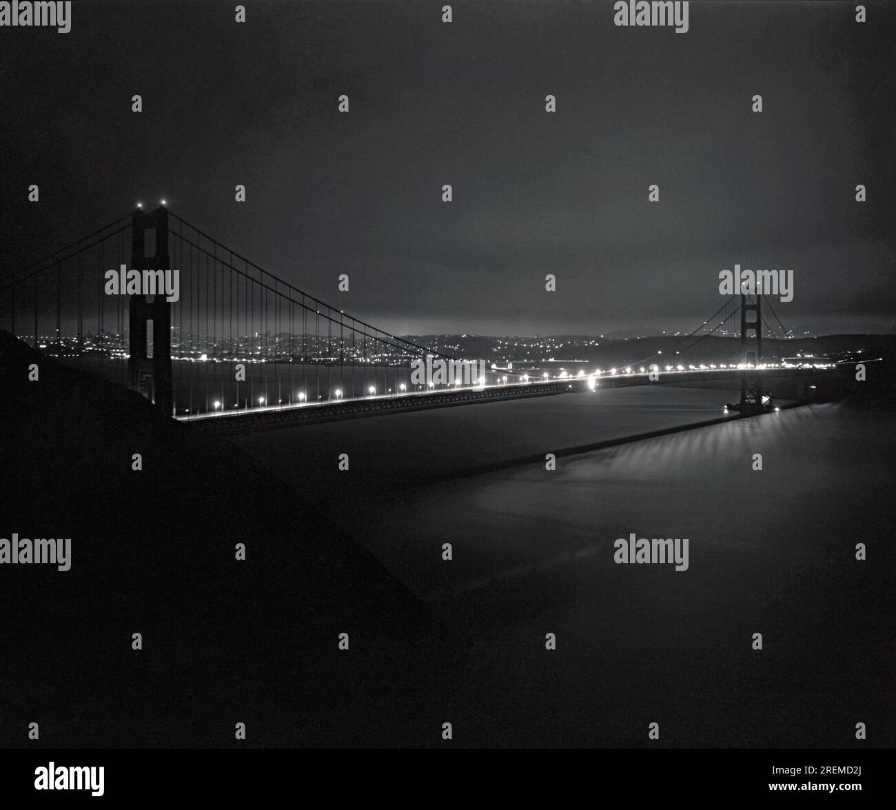 San Francisco, Kalifornien: 21. Mai 1937 die fast vollendete Golden Gate Bridge bei Nacht, mit dem letzten Schliff für ihre große Eröffnung in sechs weiteren Tagen. Das Sicherheitsnetz der Arbeiter ist immer noch an der linken Hälfte der Brücke zu sehen. Stockfoto