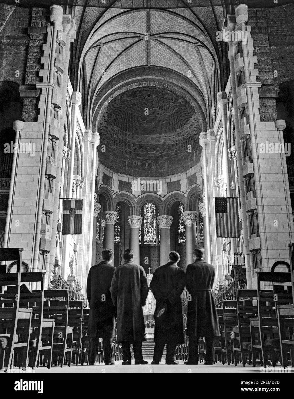 New York, New Yrok: April 1938. Vier Besucher blicken über das Schiff in Richtung des unvollendeten Heiligtums und Chors in der Kathedrale von St. John Der Göttliche. Bischof Manning hat eine Million Dollar Fondsaktion gestartet, um die Kathedrale vor der Eröffnung der Weltausstellung 1939 fertigzustellen. Stockfoto