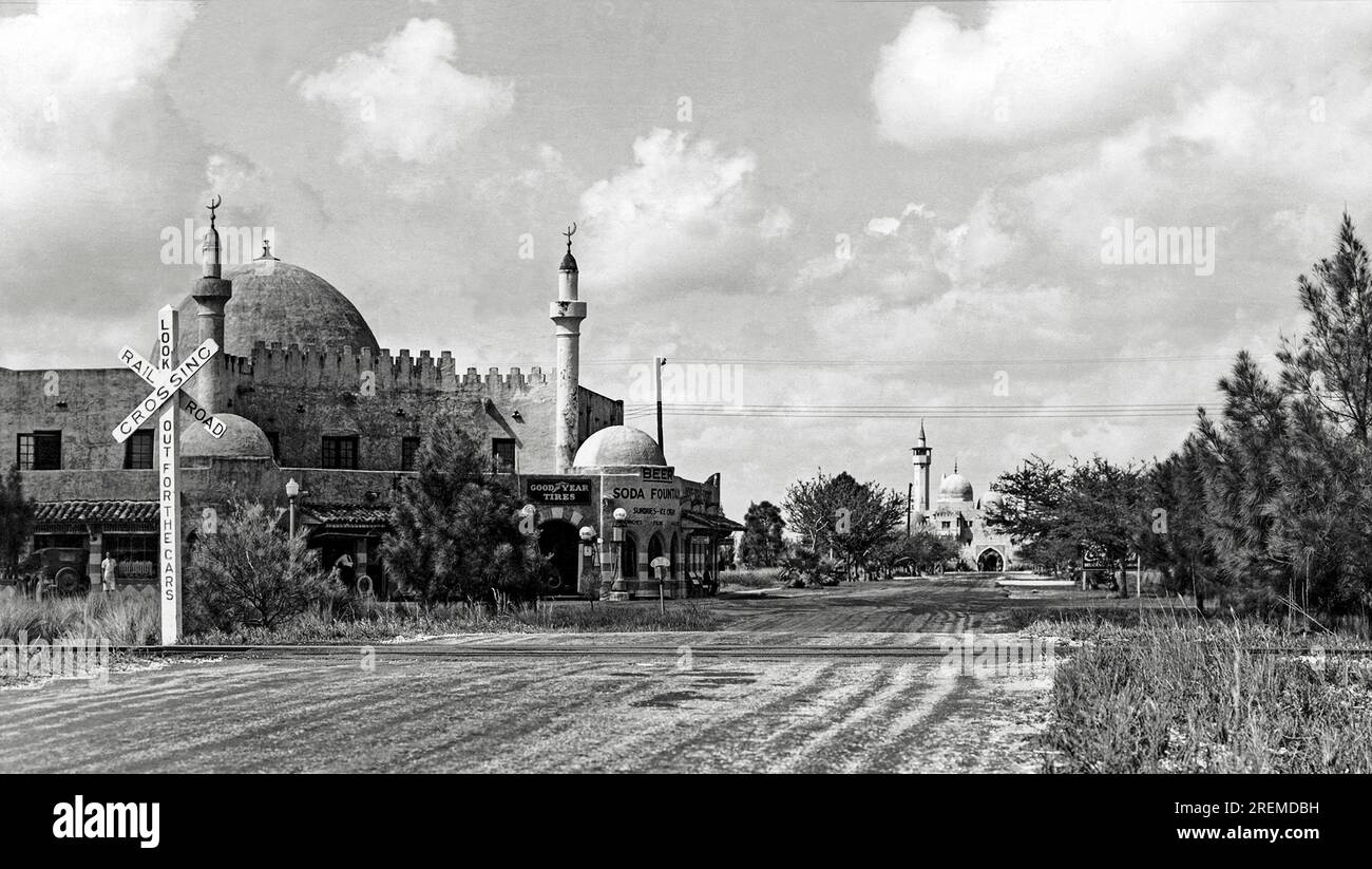 OPA Locka, Florida, 26. Februar 1935, Einfahrt in Opa Locka von Süden. Das Gebäude auf der linken Seite beherbergt den Lebensmittelladen, die Garage, die Apotheke und das Postamt. Das Gebäude British American Cinema Studies befindet sich in der Ferne. OPA Locka ist ein Vorort von Miami, der einen maurischen Look für die Architektur hier hat. Die Stadt wurde 1928 vom Flugpionier Glenn Curtis gegründet und basiert auf dem Thema Arabian Nights. Stockfoto