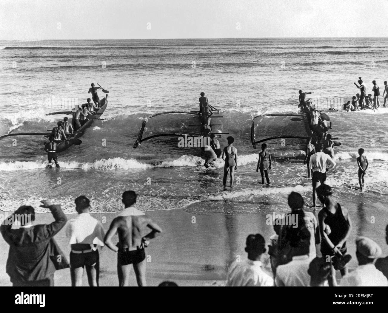 Honolulu, Hawaii: ca. 1926 der frühmorgendliche Beginn der 6-Mann-Outrigger-Kanu-Meisterschaft am Waikiki Beach auf Oahu. Das Rennen war eins vom Huli Nalu Club von Waikiki, und der Outrigger Canoe Club belegte den zweiten Platz. Stockfoto
