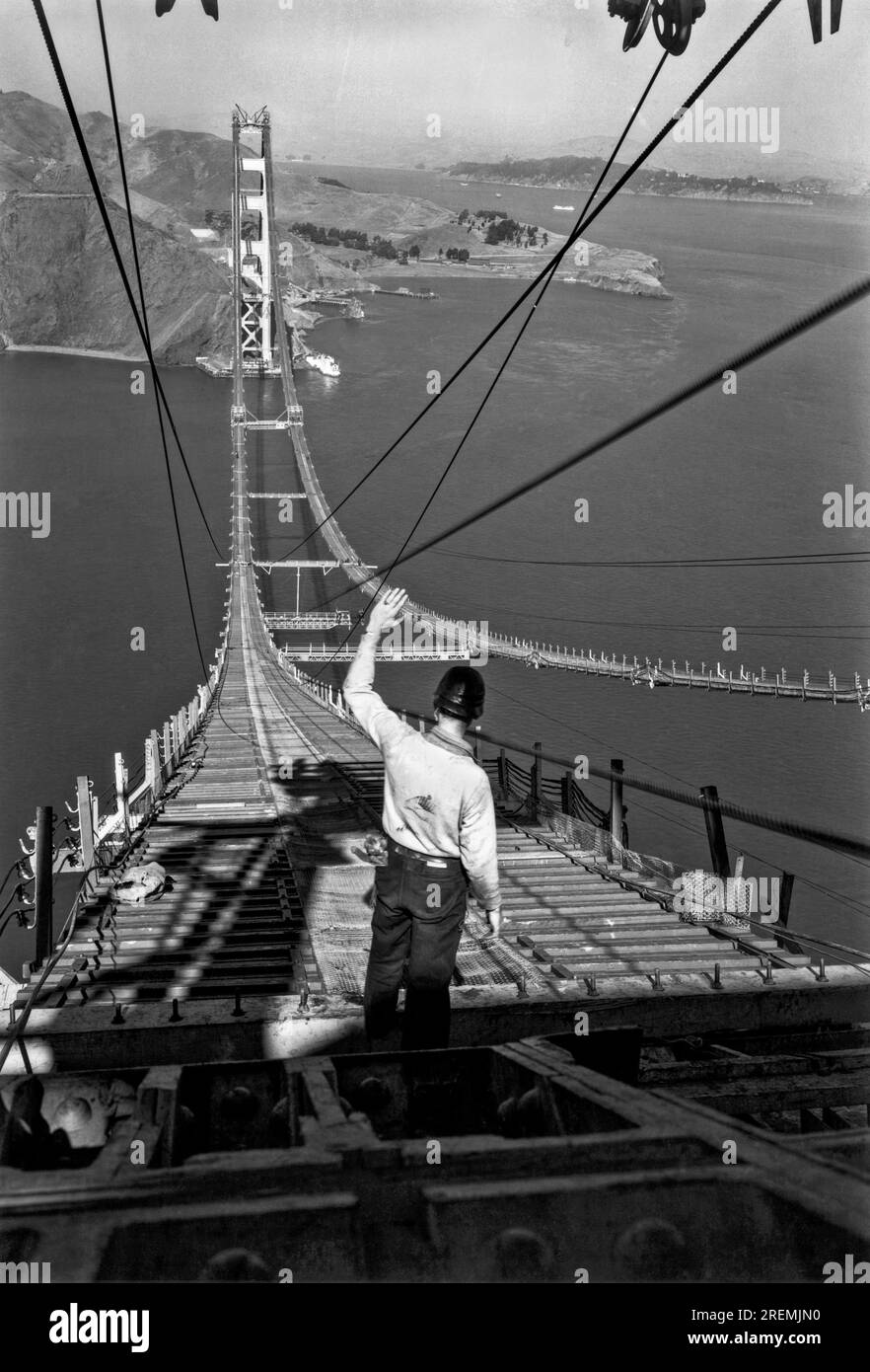 San Francisco, Kalifornien: Dezember 1935. Ein Bauarbeiter steht an einem Ende der Laufstege, die sich über das Golden Gate zwischen den beiden Türmen erstrecken. Stockfoto
