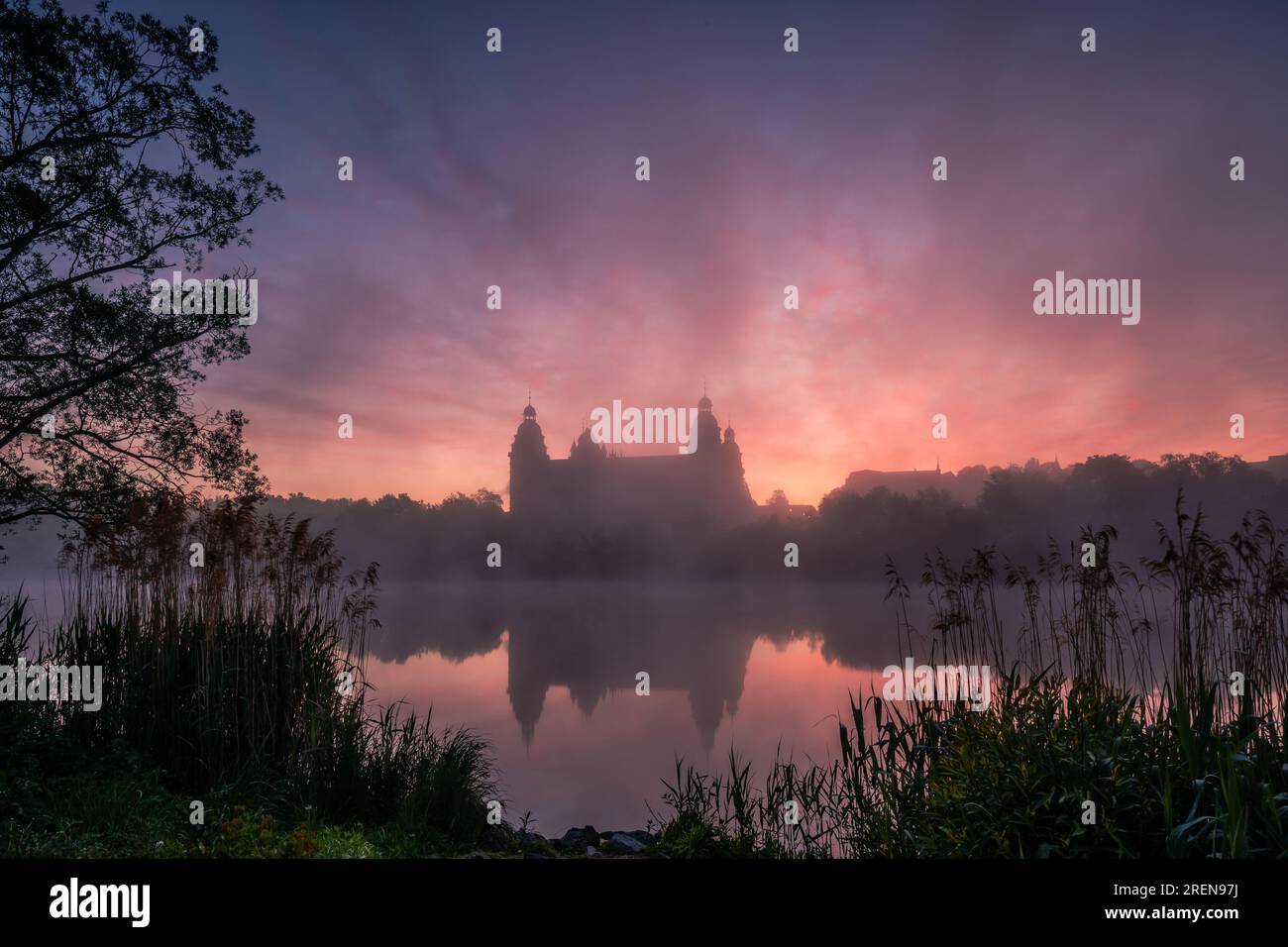 Majestätischer Sonnenaufgang im Schloss Johannisburg, Aschaffenburg: Ein Juwel am Main aus Morgennebel Stockfoto