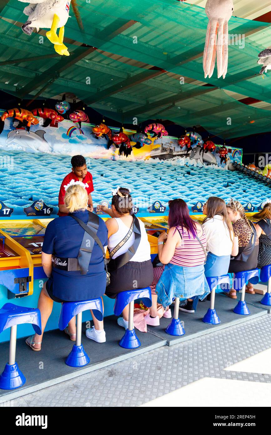 Im Vergnügungspark Brighton Palace Pier in Brighton, East Sussex, England, spielen Besucher Side-Show-Spiele Stockfoto