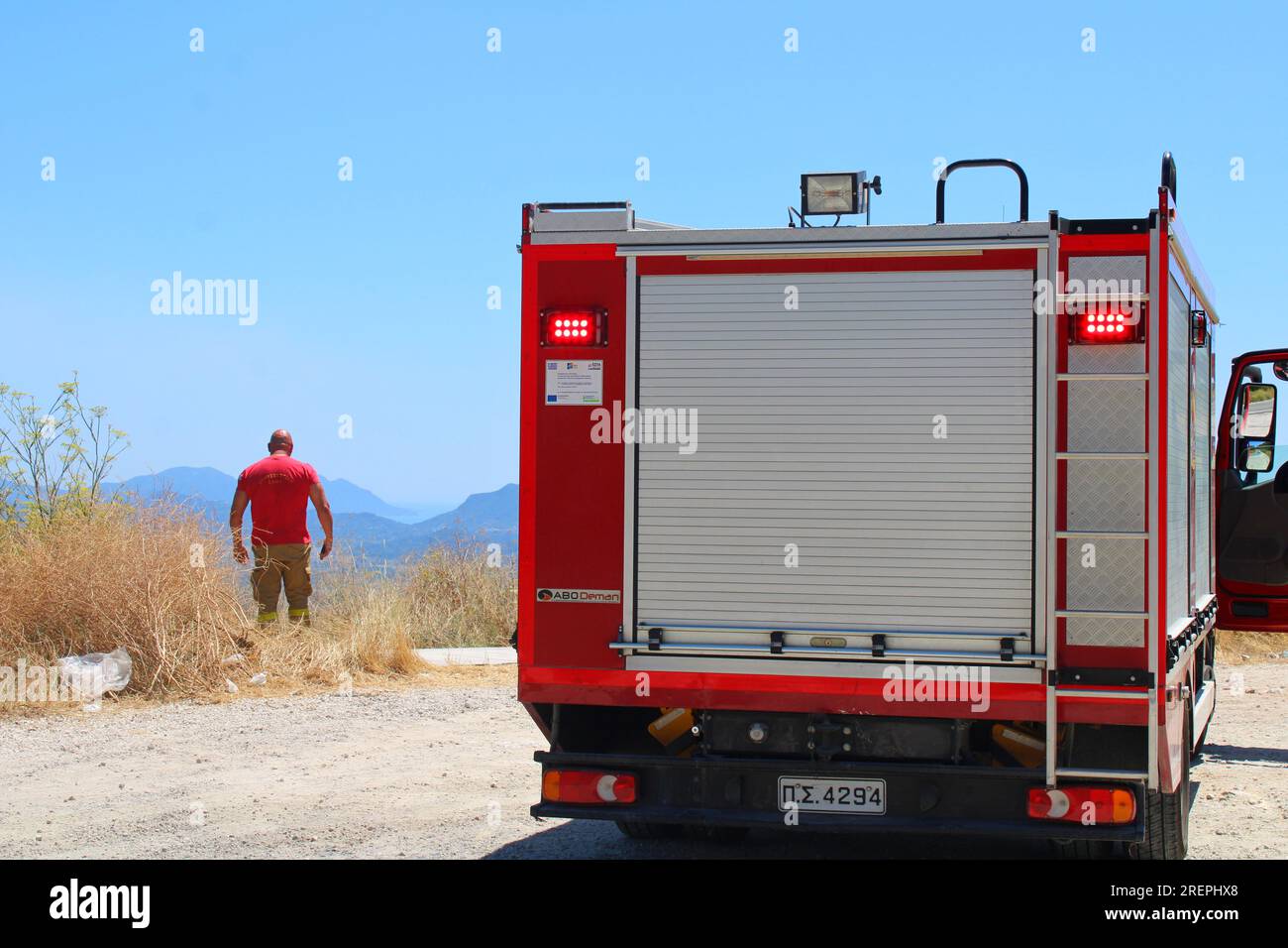 Griechischer Feuerwehrmann auf der Suche nach neuen Waldbränden von der Bergspitze in Troumpeta, Korfu Stockfoto