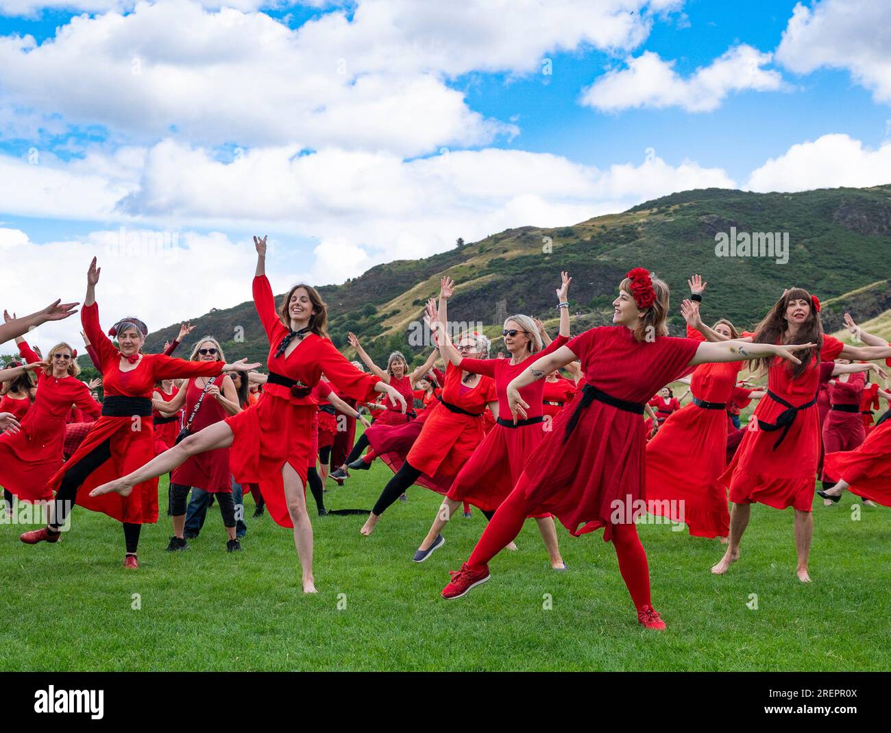 Edinburgh, Schottland, Großbritannien. 29. Juli 2023 Dutzende Frauen in roten Kleidern treffen sich im Holyrood Park, um zu tanzen und den alljährlichen „Most Wuthering Heights Day“ zu feiern – eine Hommage an die Musik von Kate Bush. Iain Masterton/Alamy Live News Stockfoto