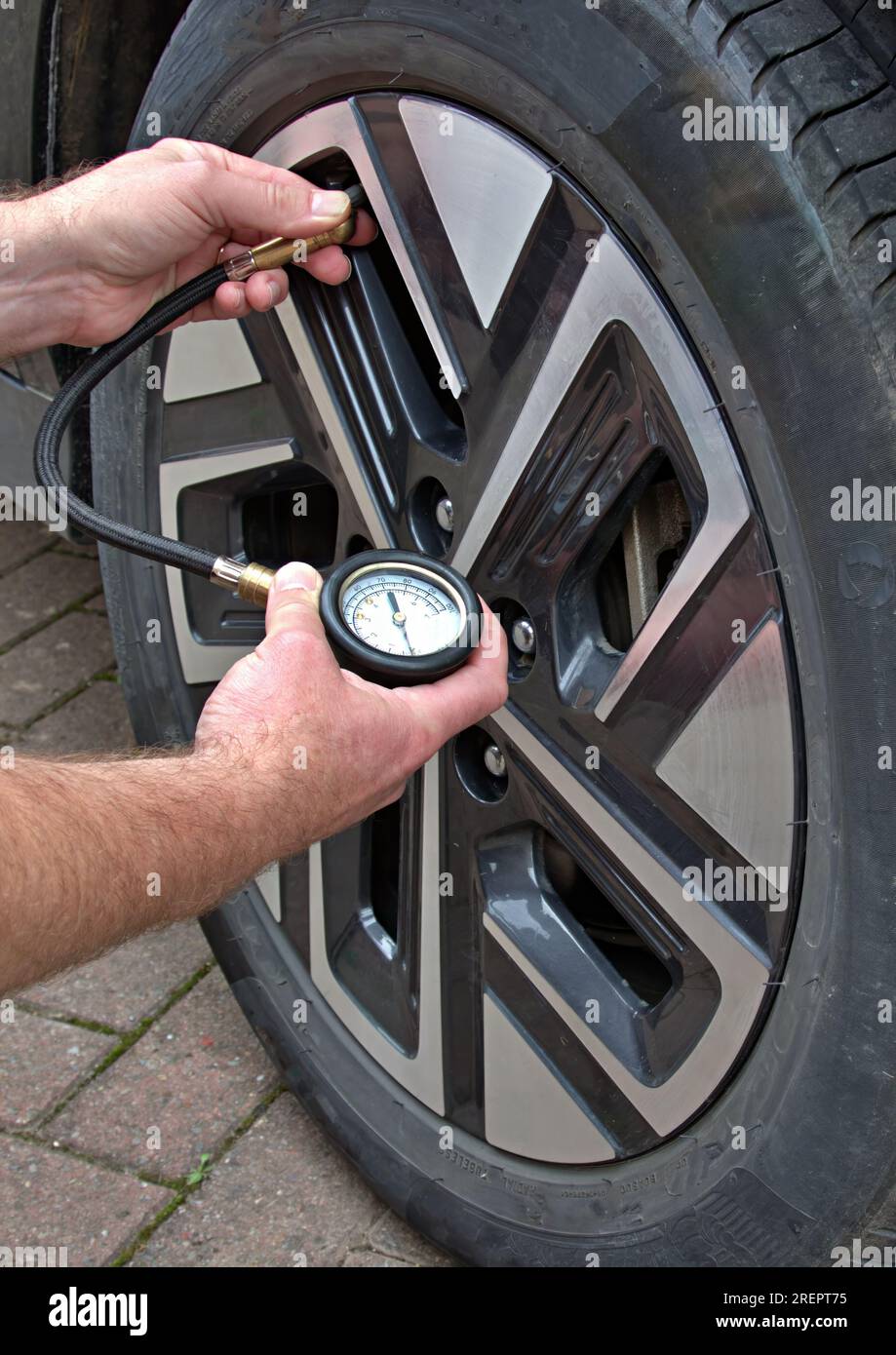 Den Reifendruck mit einem Manometer prüfen Stockfoto