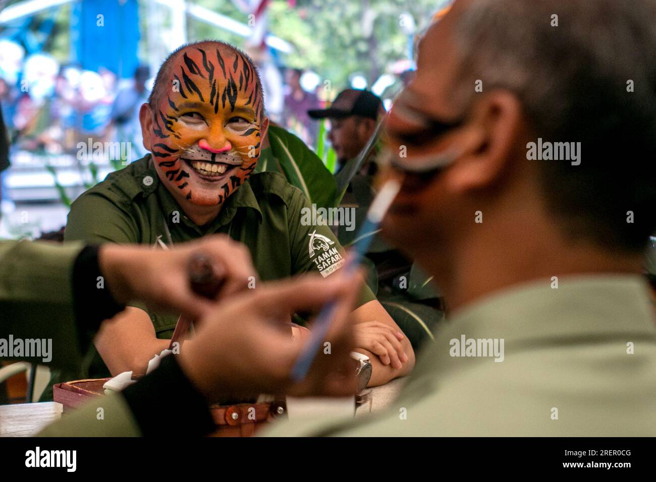 Besucher des Taman Safari Bogor, Indonesien, lassen sich am Internationalen Tigertag, der am 29. Juli gefeiert wird, mit Tigermotiven bemalten Stockfoto