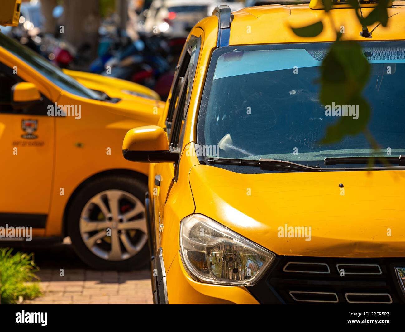 Am Sommertag fahren gelbe Autos auf der Straße durch den Verkehr Stockfoto