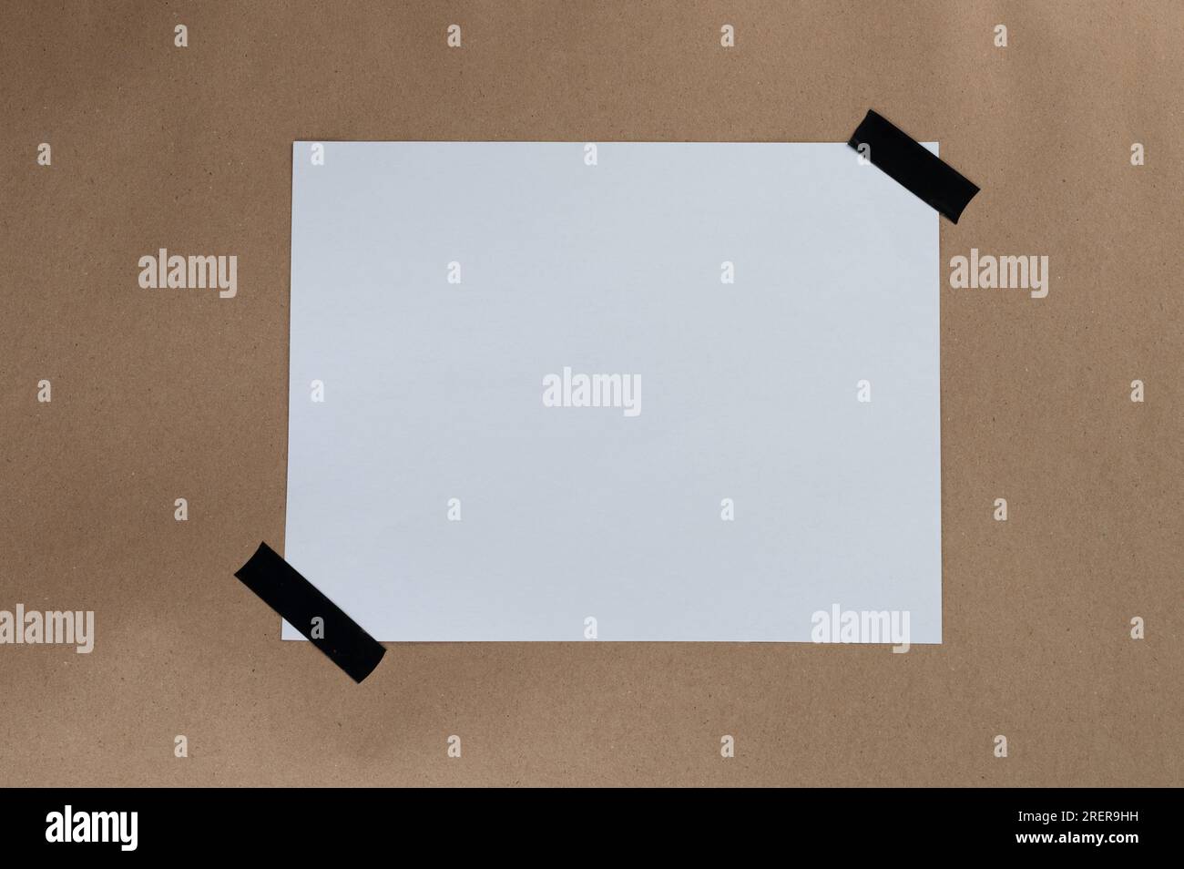 Weißes Papierblatt mit schwarzer Klebestreifen auf braunem Recycling-Hintergrund Stockfoto
