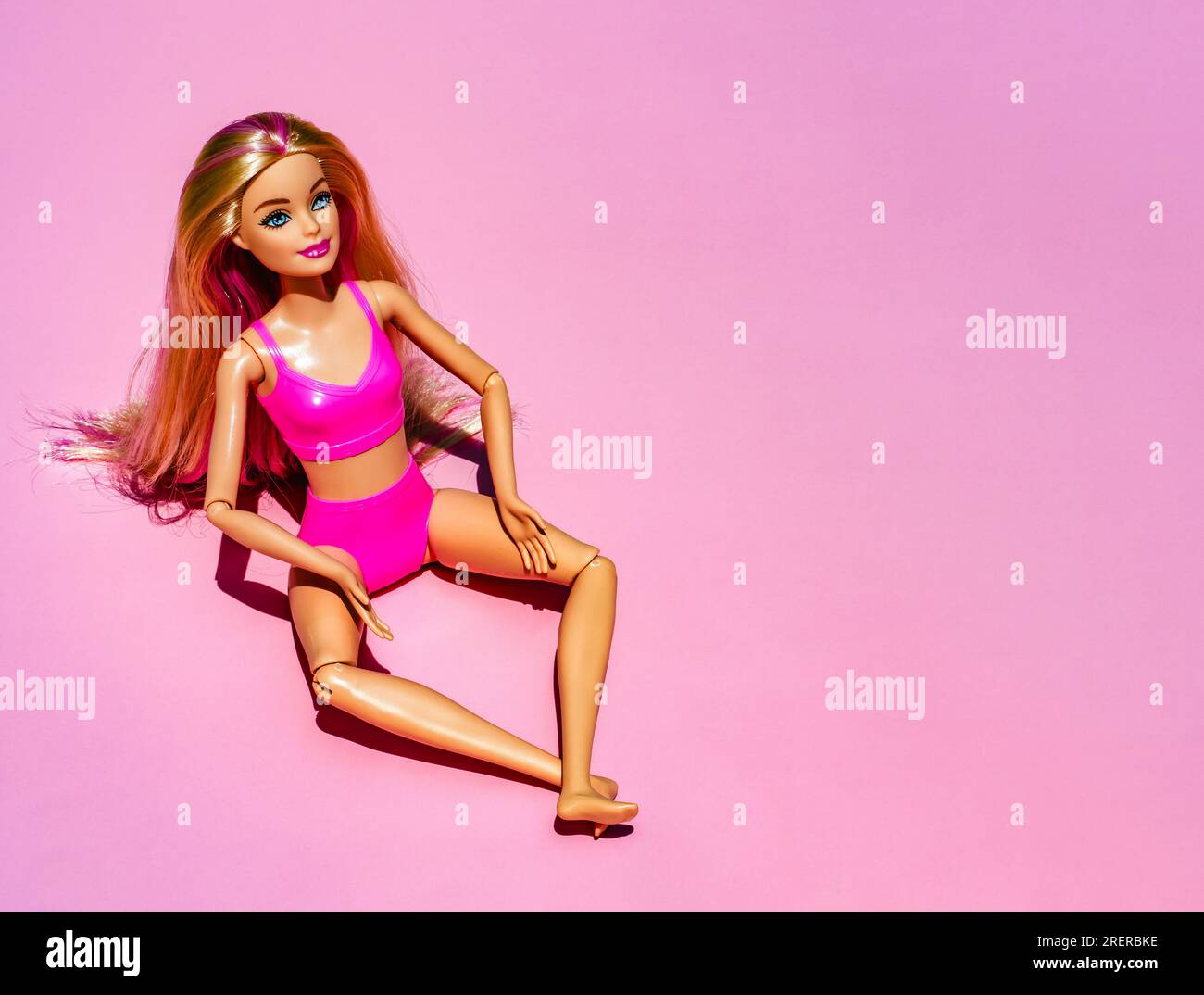 Nizza, Frankreich - 29. JULI 2023: Blonde Puppe mit pinkfarbenem Badeanzug und Accessoires auf pinkfarbenem Hintergrund. Trendige, moderne Barbie mit flachen Füßen. Hohe Qualität Stockfoto