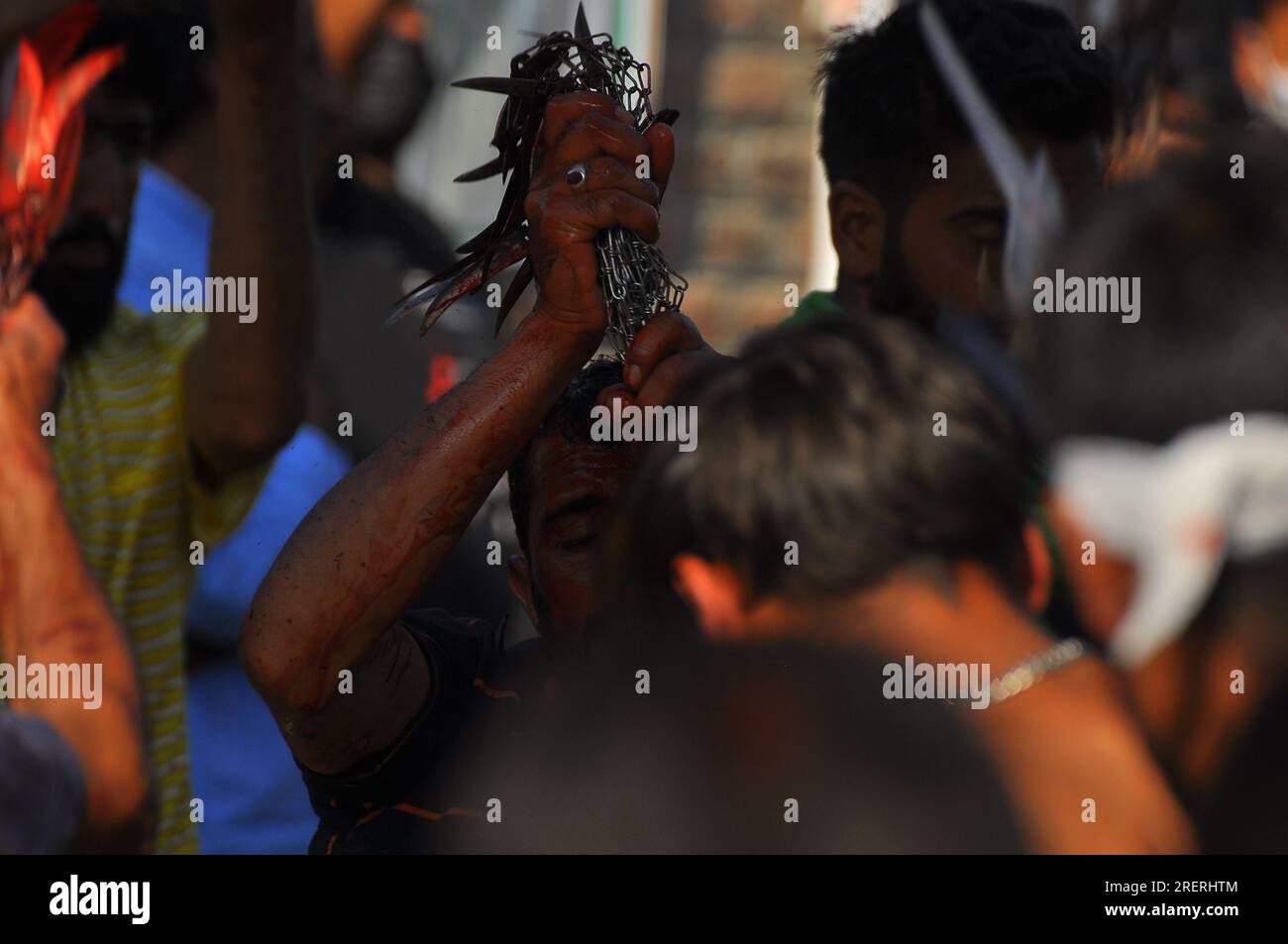 Ein Junge hält Eisenketten mit einem Messer während der muharram-Prozession am Zadibal-Sringar Stockfoto