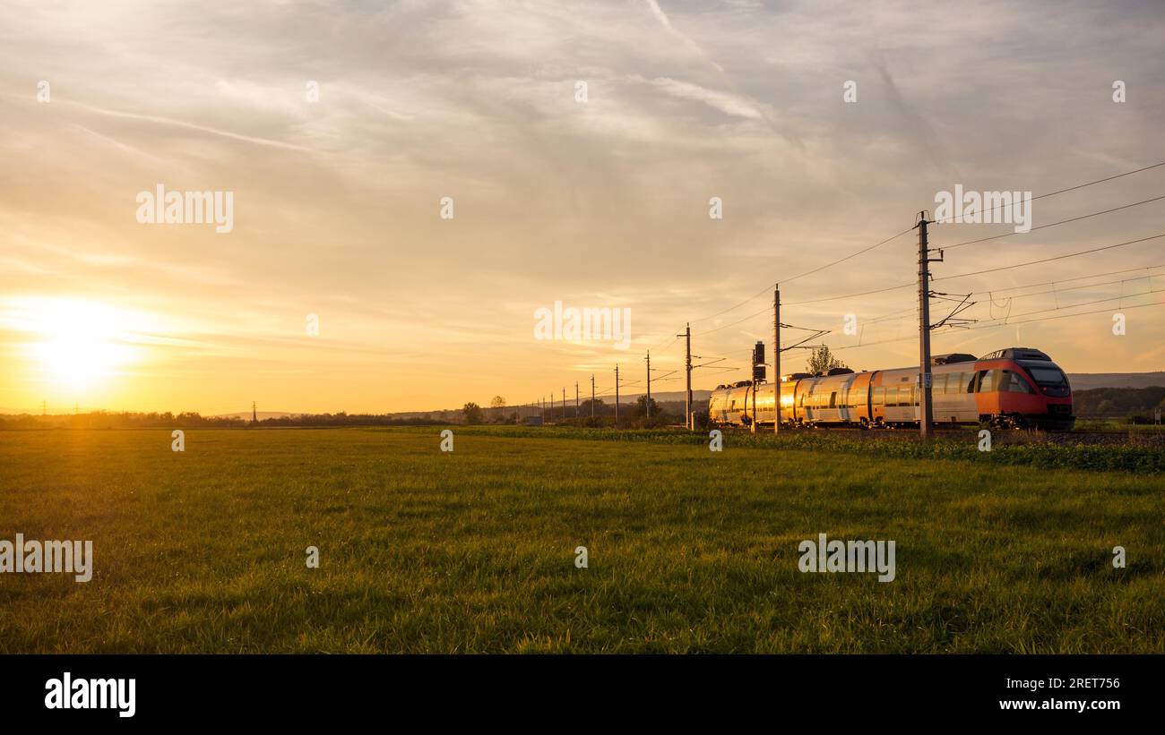 Zug fährt in das Licht der untergehenden Sonne Stockfoto