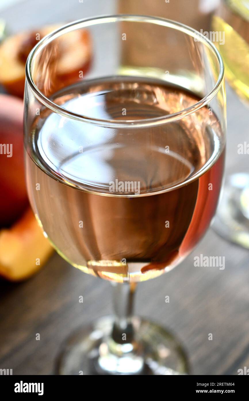 Gläser Pfirsichwein auf einem dunklen Holztisch Stockfoto