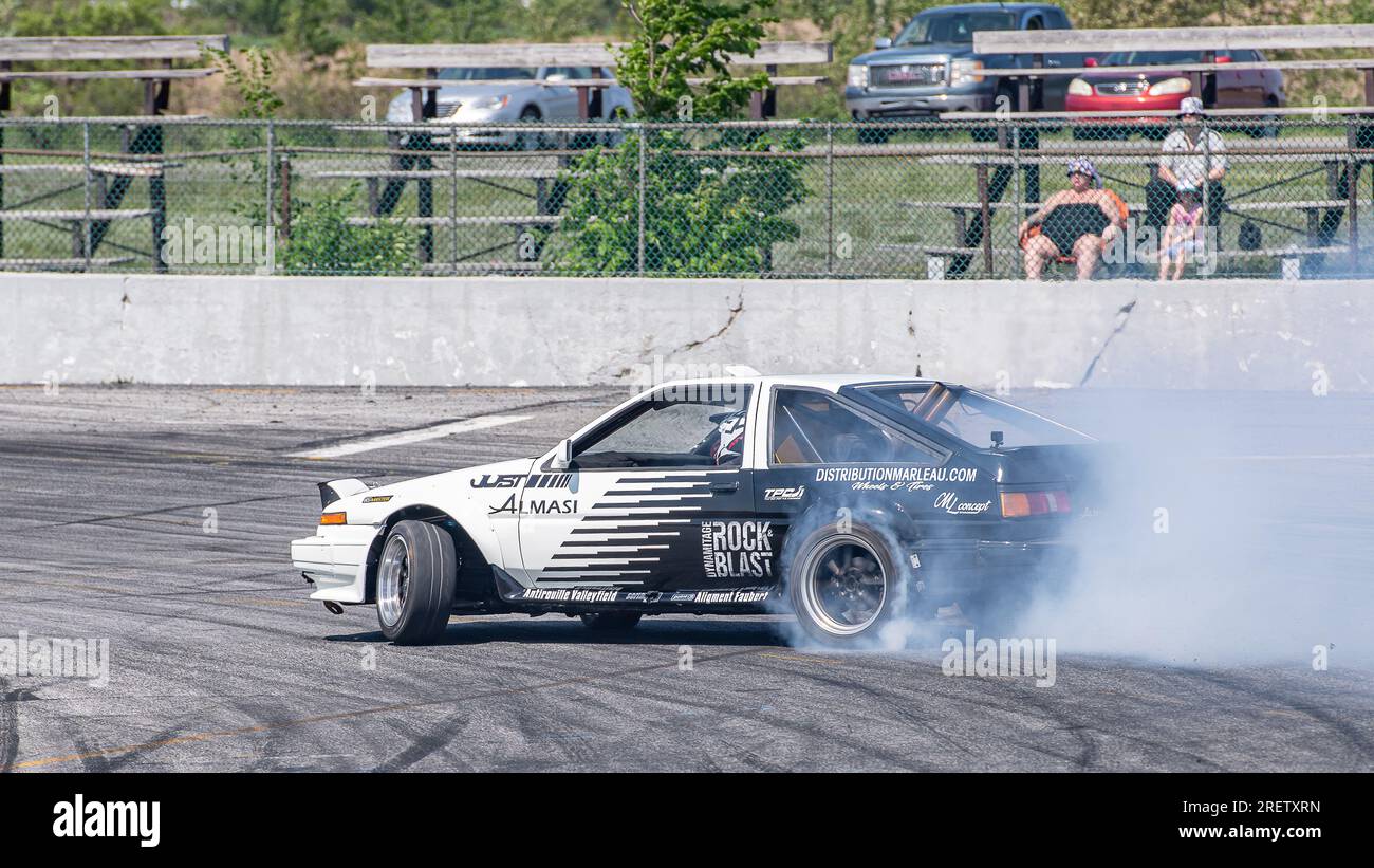 Autorennbahn-Action mit Räucherreifen – brennende Reifen auf der Rennstrecke in Bewegung. Sanair Superspeedway, Kanada, Quebec Stockfoto