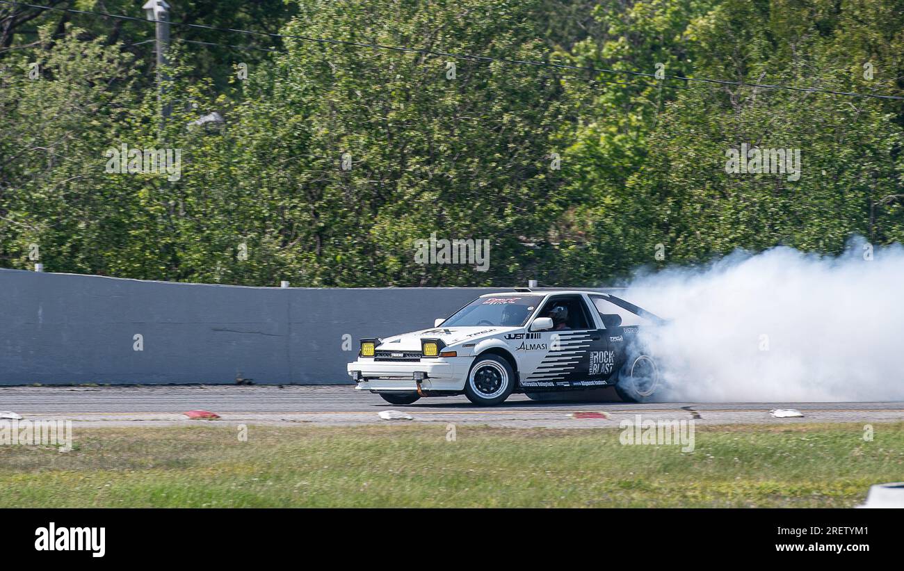 Autorennbahn-Action mit Räucherreifen – brennende Reifen auf der Rennstrecke in Bewegung. Sanair Superspeedway, Kanada, Quebec Stockfoto