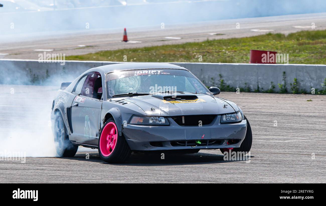 Autorennbahn-Action mit Räucherreifen – brennende Reifen auf der Rennstrecke in Bewegung. Sanair Superspeedway, Kanada, Quebec Stockfoto