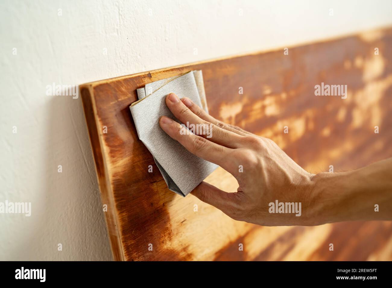 Schrubben von Holzplatten mit Schleifpapier Stockfoto