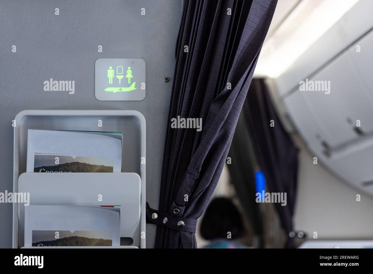 Die grün beleuchtete Toilettenschilder an der Wand der Flugplankabine deuten darauf hin, dass sie nicht besetzt ist Stockfoto