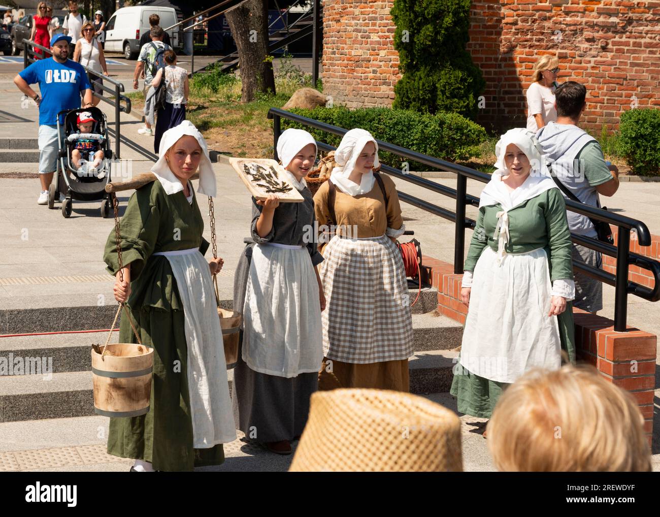 Weibliche Reenaktoren, die als mittelalterliche Straßenverkäufer am Targ Rybny oder Fischmarkt in der Altstadt von Danzig, Polen, gekleidet sind Stockfoto