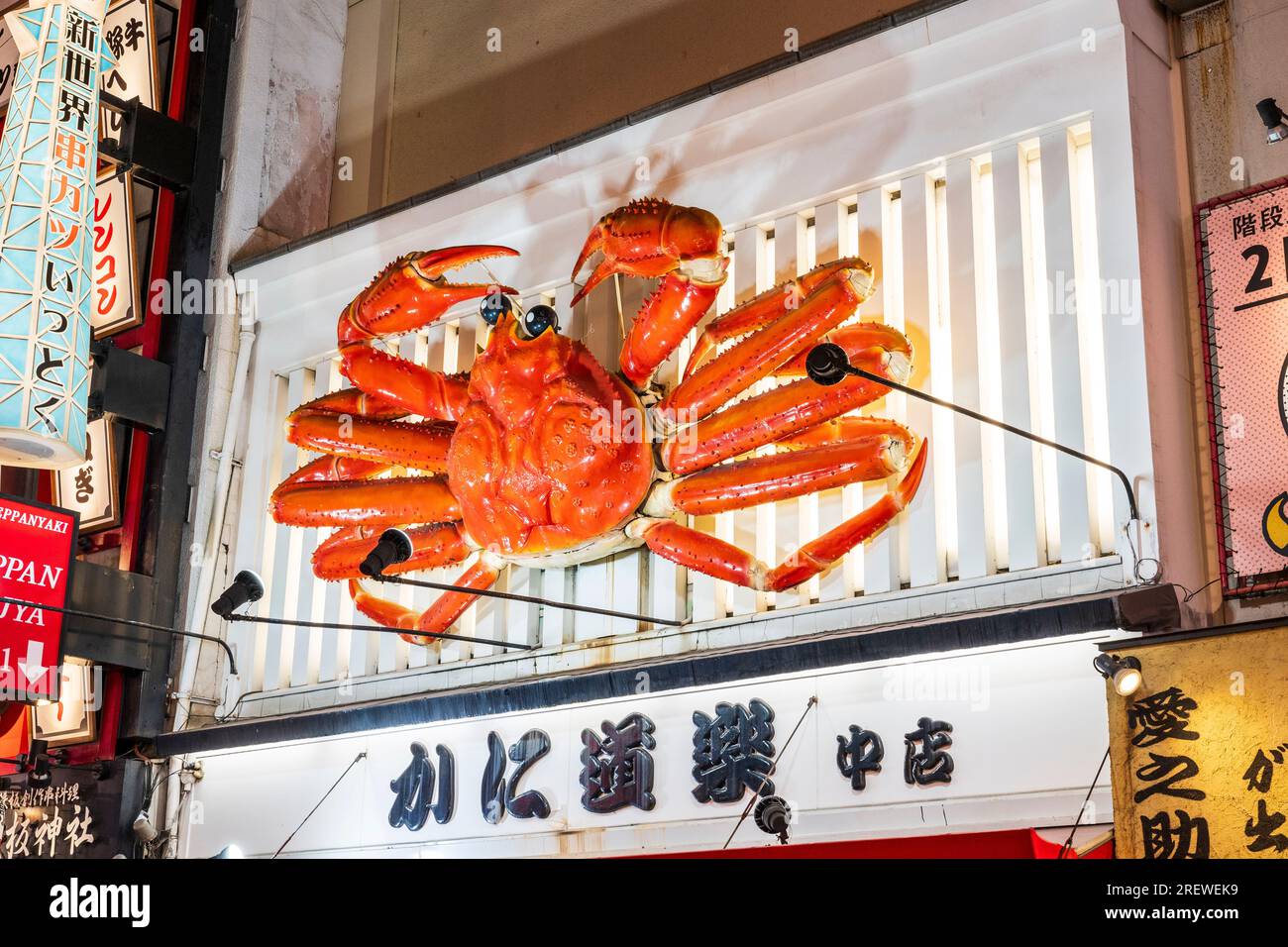 Die berühmte bewegliche Krabbe wird nachts beleuchtet, über dem Eingang zum Kani Doraku Dotombori Nakamise Restaurant, Dotonbori, Osaka. Stockfoto