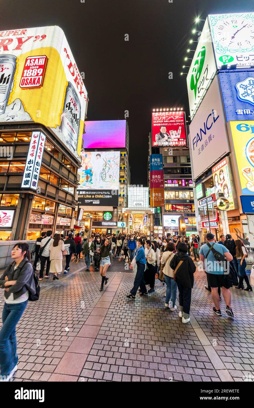 Die beliebte und überfüllte Ebisu-Brücke in Dotonbori, Osaka, mit dem Restaurant Kani Doraku und dem Eingang der Ebisu Bashi suji-Einkaufspassage. Es Ist Nacht Stockfoto