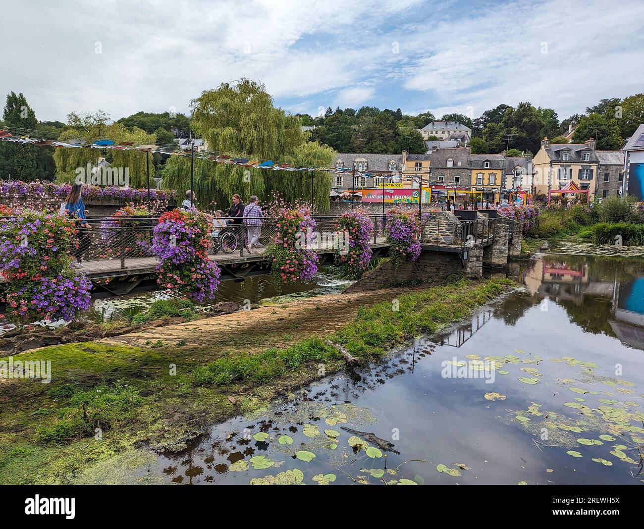 C) Denis TRASFI / MAXPPP - France, Bretagne, Morbihan, Maison Yves Rocher à Gacilly le 20 juillet 2023 - Pont piéton fleuri au-dessus de la rivière L. Stockfoto