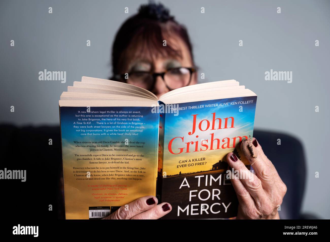 Eine Frau, die John Grisham Einen "Time for Mercy" -Krimi liest Stockfoto