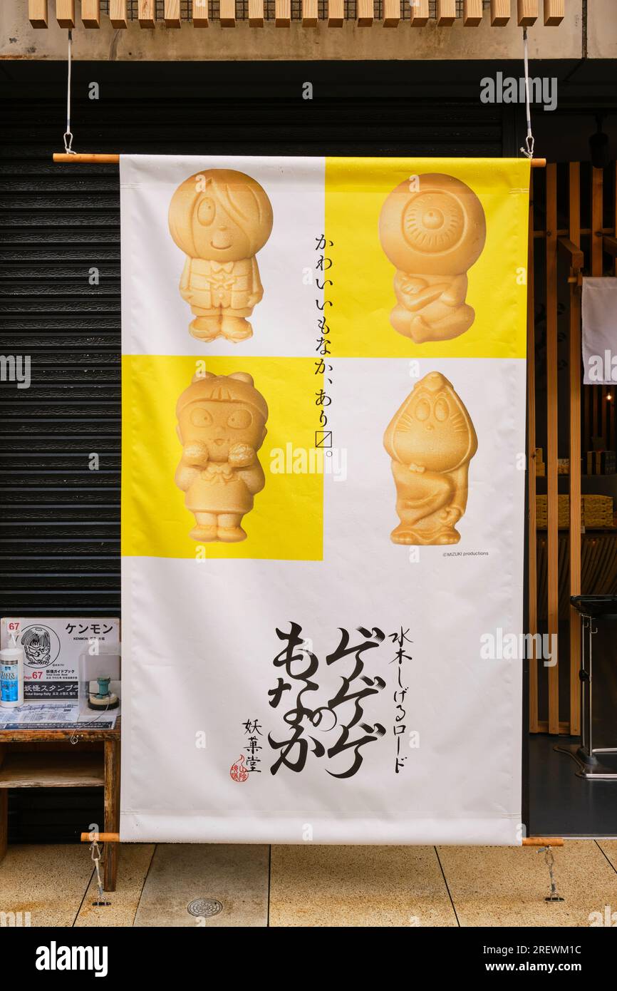 Juni 2023, Sakaiminato. Auf dem Poster am Schaufenster entlang der Mizuki Shigeru Road werden GeGeGeGe No Kitaro Yokai Snacks zum Verkauf angeboten. Stockfoto