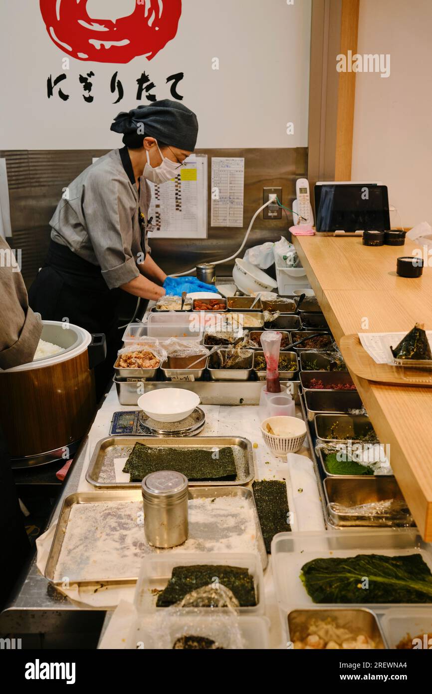 Juni 2023, Nagoya. Mitarbeiter im Geschäft bereitet frischen Reisball (Musubi) für Kunden im Einkaufsviertel Osu zu Stockfoto