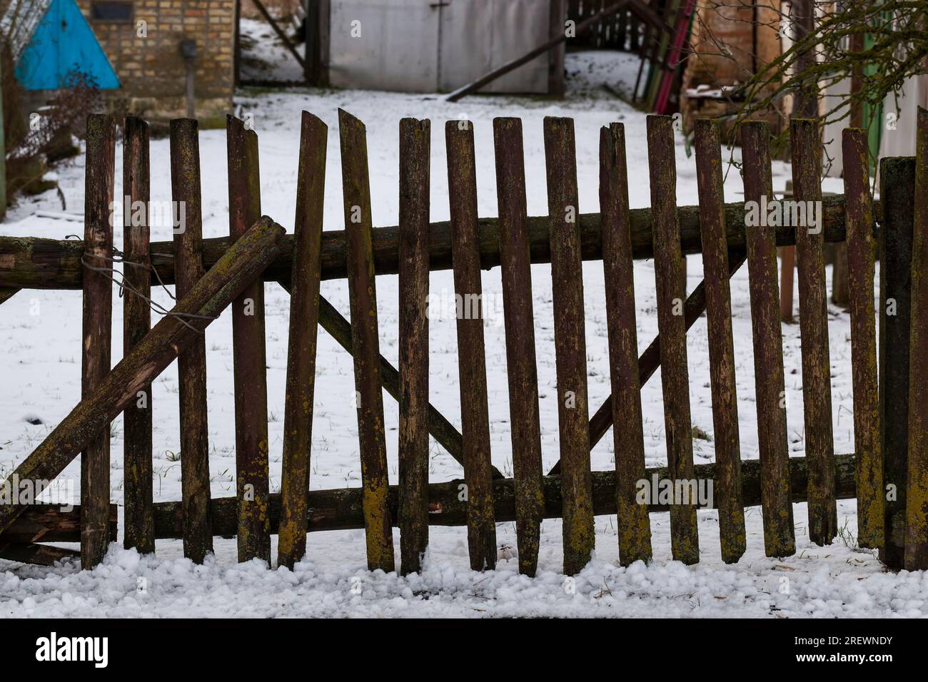 Details des alten Holzzauns, der einen Bereich in ländlicher Umgebung umgibt, ein Zaun aus Holzzaun, der wenig Schutz bietet, viele Probleme Stockfoto