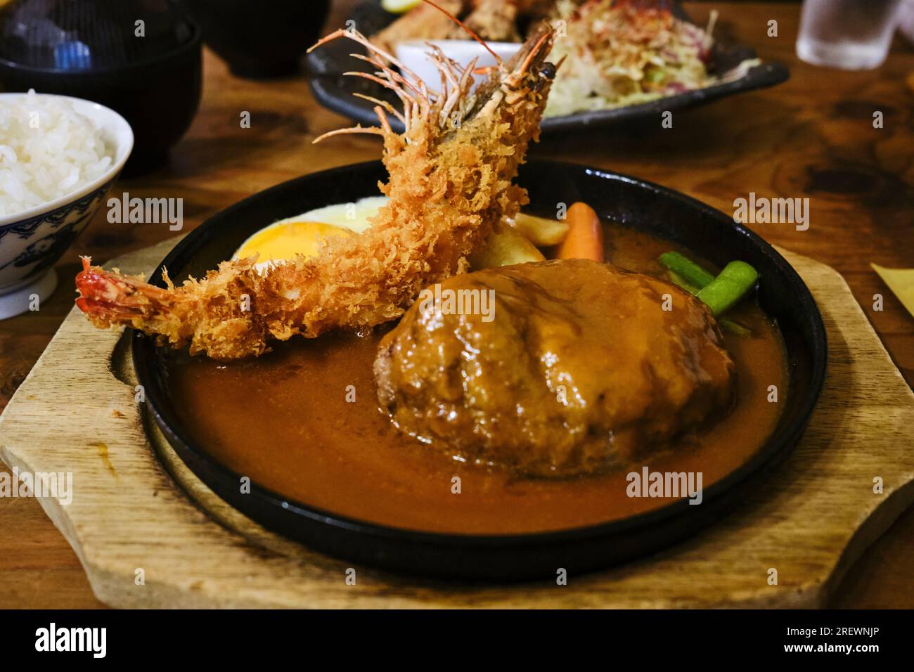 Juli 2023, eine japanische Kochplatte bestehend aus einer Garnelen-Tempura, einem japanischen Hamburger (Hambagu), Spiegelei und Gemüse Stockfoto